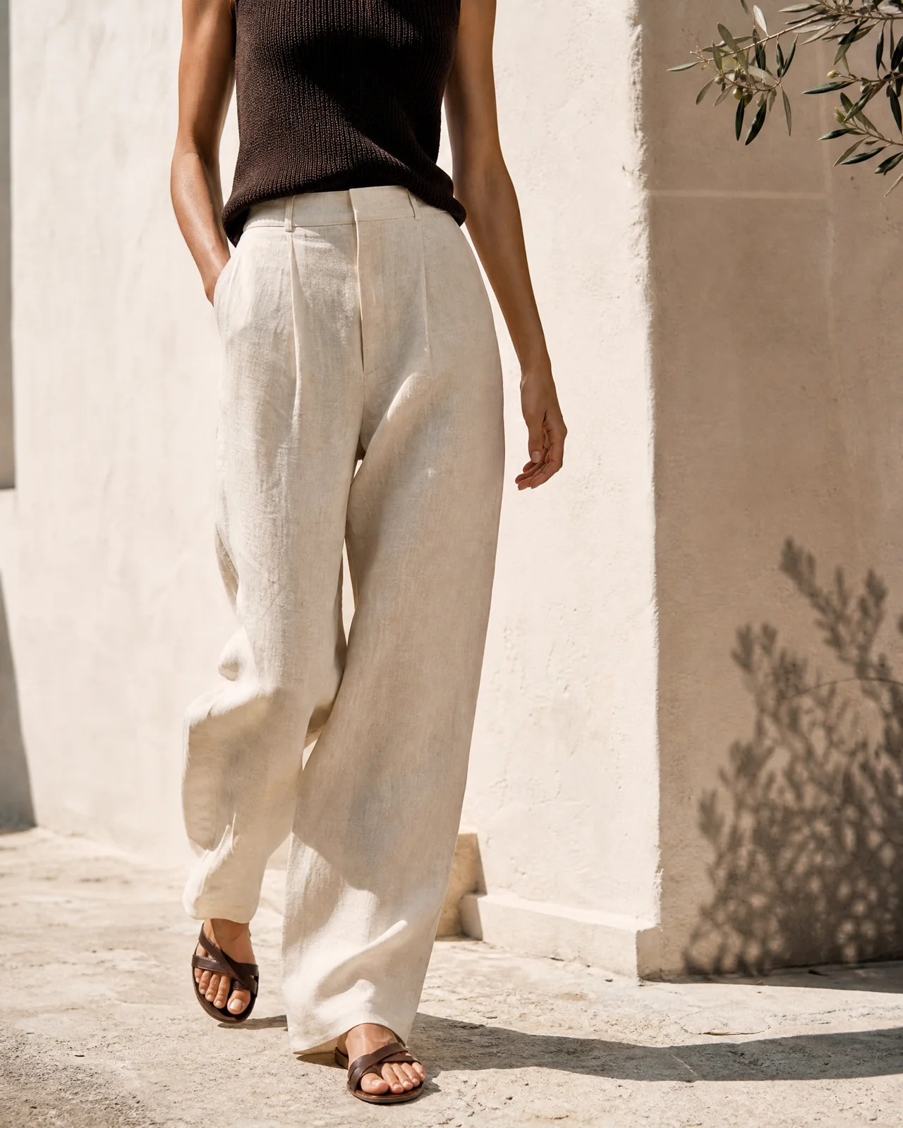 Pantalón de lino crudo caminando junto a una pared mediterránea